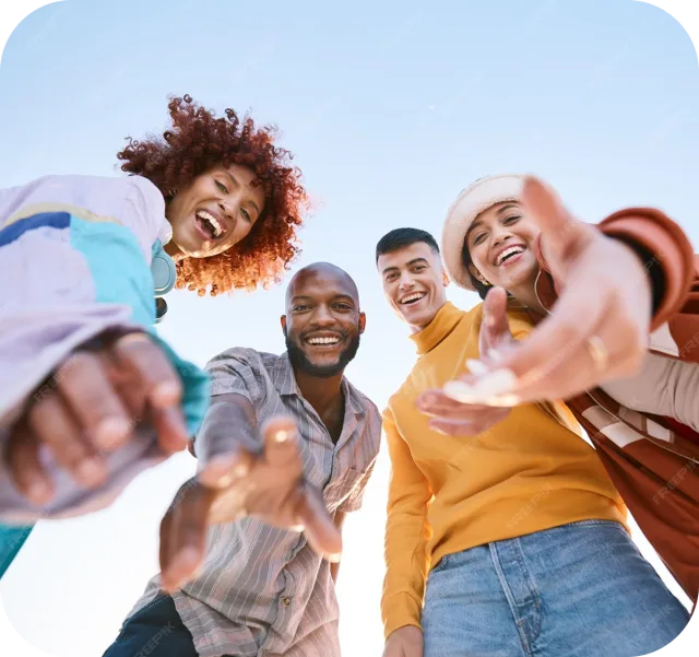Friends laughing and reaching toward the camera at an outdoor event